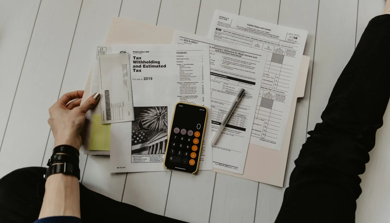 Notebook and calculator next to an open ledger on an office desk